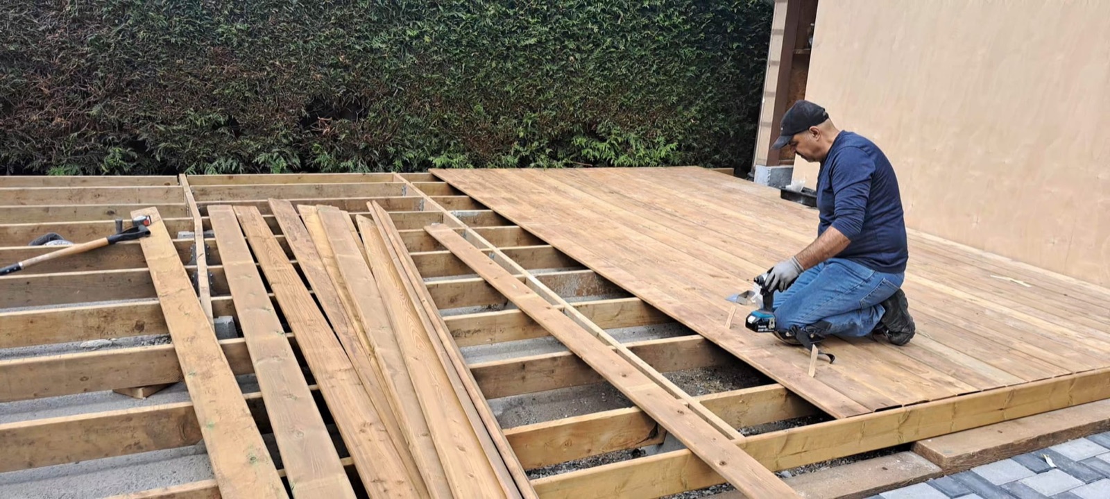 Laying pressure-treated deck boards over new joist framing