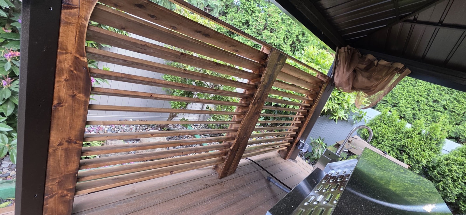 Finished cedar pergola and privacy screen over a backyard deck